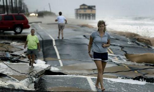 三个人走在被风暴破坏的路上. 